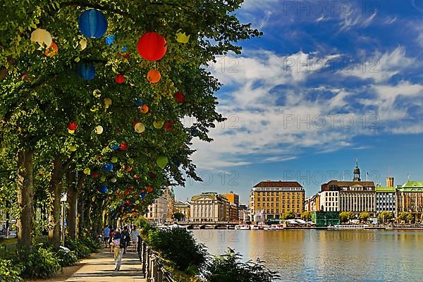 The trees on Ballindamm by the Inner Alster Lake are decorated with lanterns at Hamburg's summer gardens