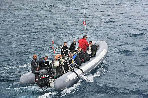 Divers travel to their dive site in an inflatable boat
