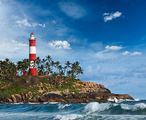 Old lighthouse and waves of sea. Kovalam