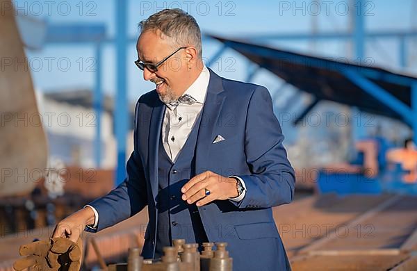 Laughing mafia boss in blue suit at the harbour