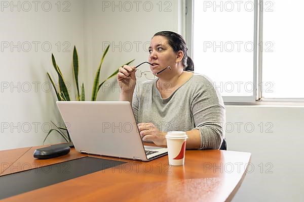 Mature business woman sitting at the head of the table in an office meeting room