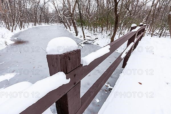 Rustic bridge over frozen river in winter