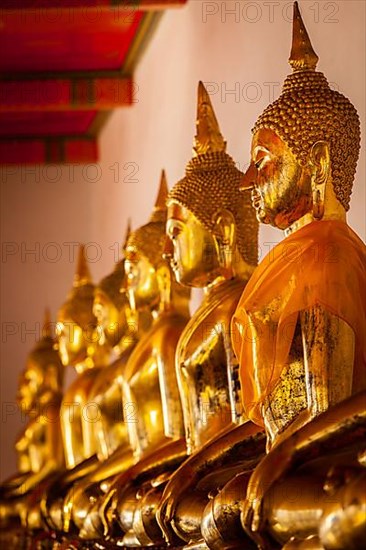 Row of sitting Buddha statues in Buddhist temple Wat Pho