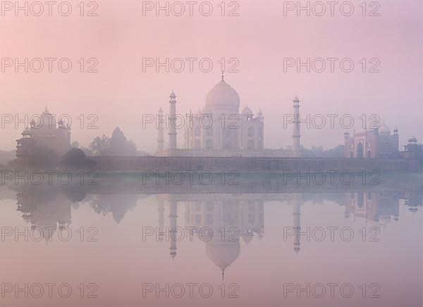 Taj Mahal on sunrise sunset reflection in Yamuna river panorama in fog