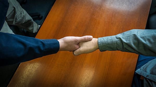 Close-up overhead shot of two men shaking hands. Concept of deal