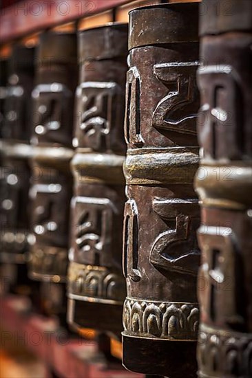 Tibetan Buddhist prayer wheels in Buddhism temple. Shallow depth of field. Rewalsar