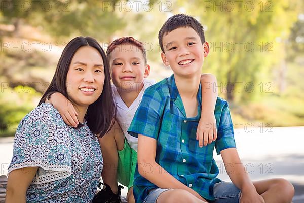 Outdoor portrait of biracial chinese and caucasian brothers and their mother