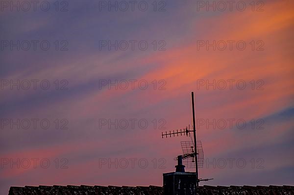 Antenna mast in front of red-blue sky at sunset