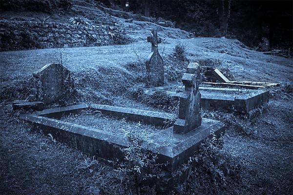 Spooky Halloween graveyard in fog in moonlight