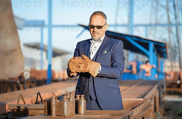 Mafia boss with rough tool takes off leather gloves