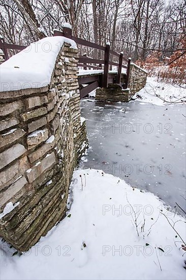 Rustic bridge over frozen river in winter