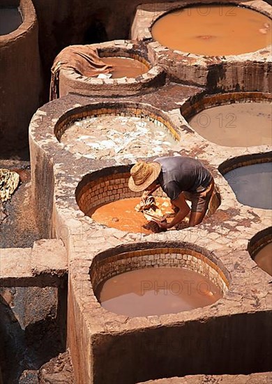 Workers dyeing leather