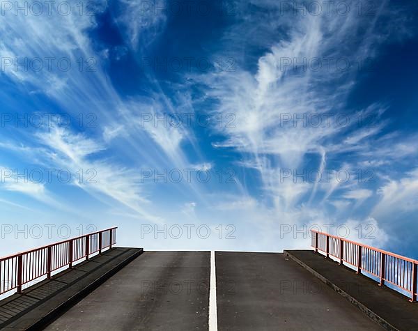 Asphalt road going into sky with clouds