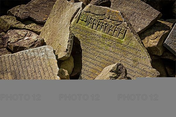 Buddhist prayer mantras on stones in Tibetan Buddhism temple