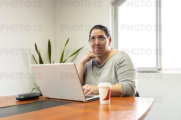 Mature business woman sitting at head of table in office meeting room