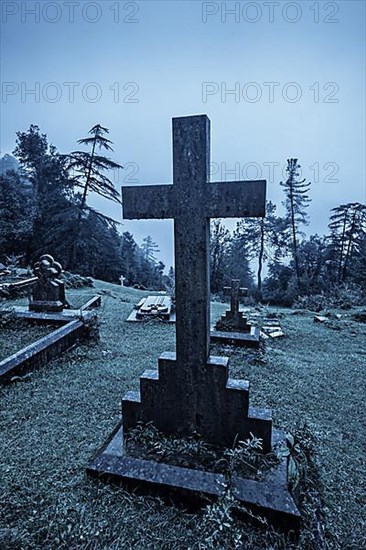 Spooky Halloween graveyard in fog in moonlight