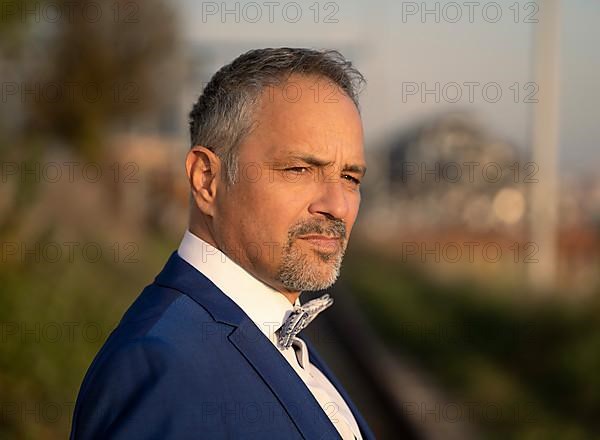 Thoughtful man in blue suit with bow tie