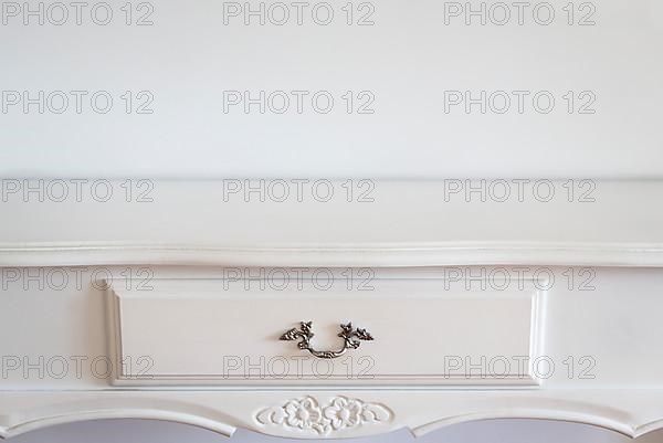 Close up of a white classic console over a white wall