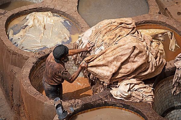 Workers dyeing leather