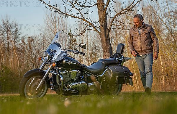Man in leather jacket circles his motorbike