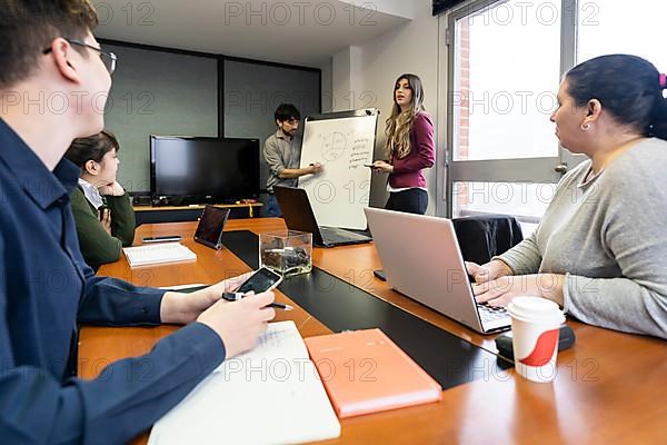 Employees making a presentation to their office colleagues in the meeting room