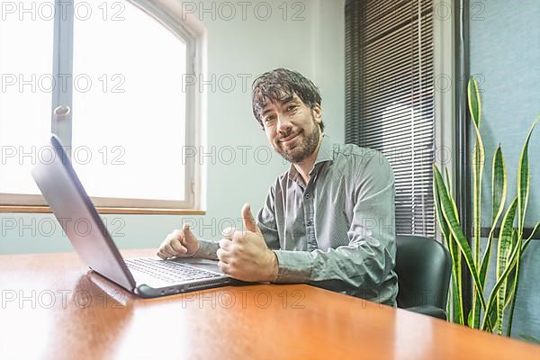 Businessman sitting at his desk working on his notebook