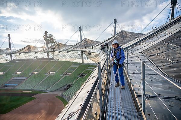 Woman with safety equipment on the tent roof of the Olympic Stadium