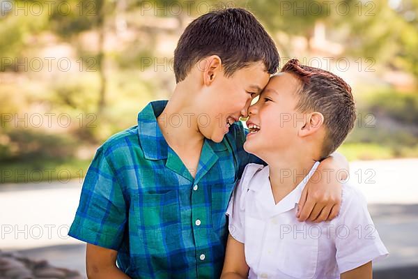 Outdoor portrait of biracial chinese and caucasian brothers having fun