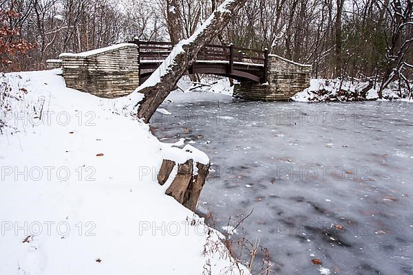 Rustic bridge over frozen river in winter