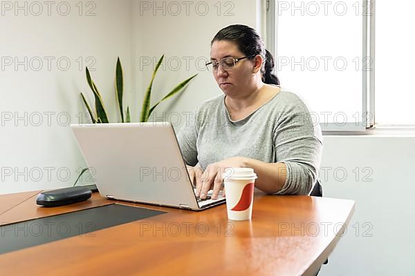 Mature business woman sitting at the head of the table in an office meeting room