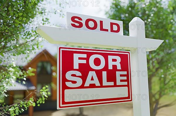 Sold for sale real estate sign in front of property