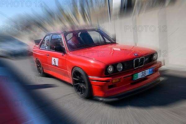 Dynamic photo with zoom effect of sports car racing car red BMW M3 S54 leaving pit lane