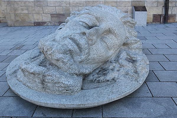 Large stone sculpture with the head of John the Baptist in front of St. John in Donaueschingen