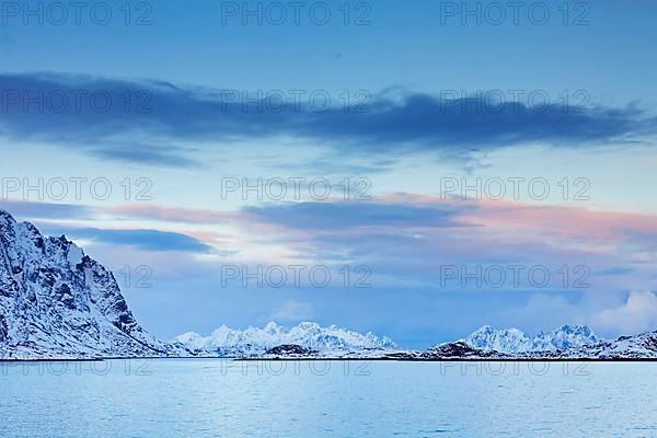 Mountains in the snow in winter by the fjord of Henningsvaer