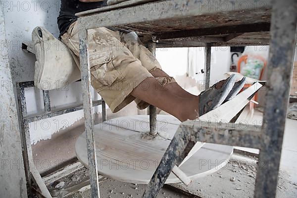 Legs at a pottery table