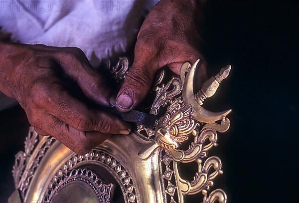 An artisan carving bronze kuthu vilakku bronze oil lamp making at Kunnamangalam