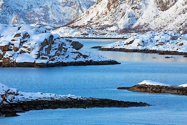 Mountains in the snow in winter by the fjord of Henningsvaer