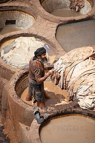 Workers dyeing leather