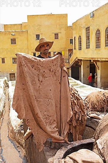 Workers dyeing leather