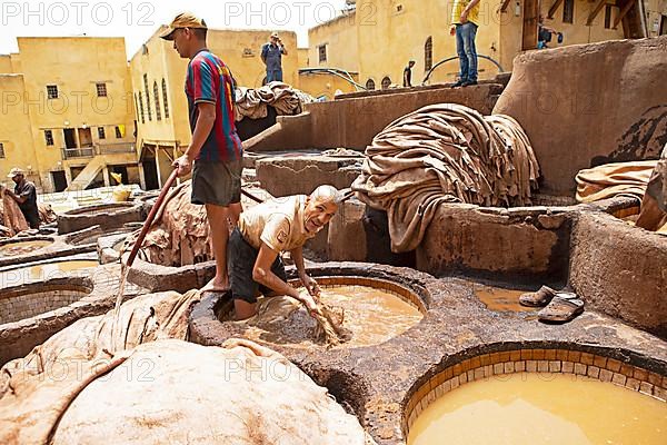 Workers dyeing leather