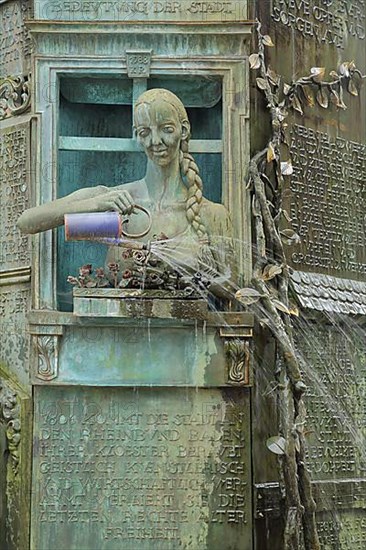 Minster fountain by Klaus Ringwald 1989 with detail figure of a woman watering flowers with watering can