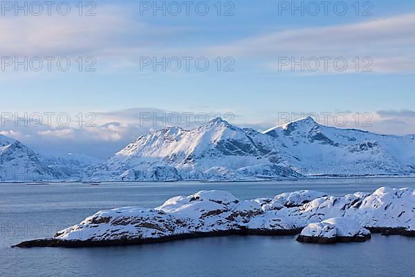 Mountains in the snow in winter by the fjord of Henningsvaer