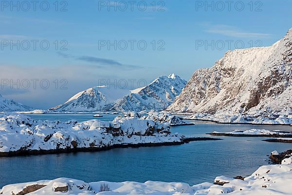 Mountains in the snow in winter by the fjord of Henningsvaer