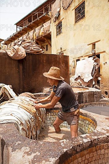 Workers dyeing leather