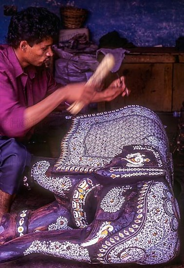An artisan making inlay work a rosewood elephant at Mysore