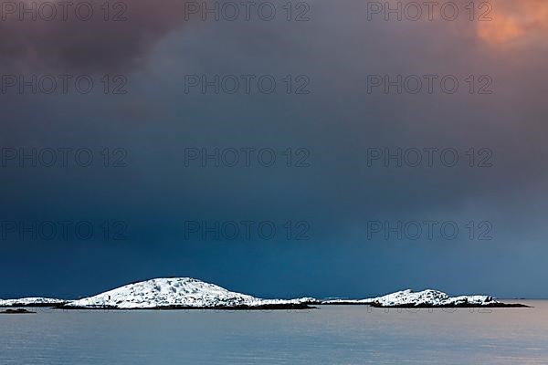 Storm clouds over Bergen in the snow in winter at the fjord of Henningsvaer