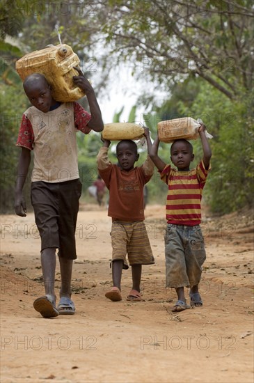 Children collecting water from a well and carrying it home