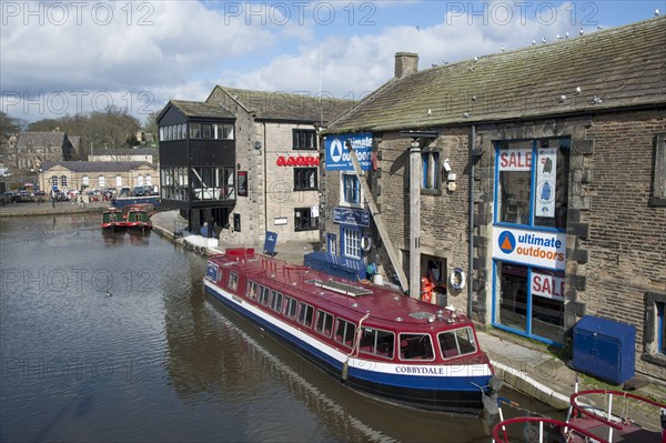 Excursion boat and narrowboats moored on the canal in the city