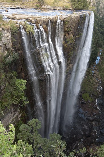 View of curtain type waterfall dropping into slot canyon