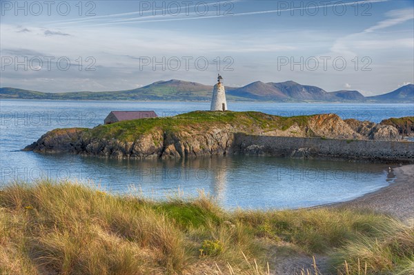 View of lighthouse and coastline on tidal island